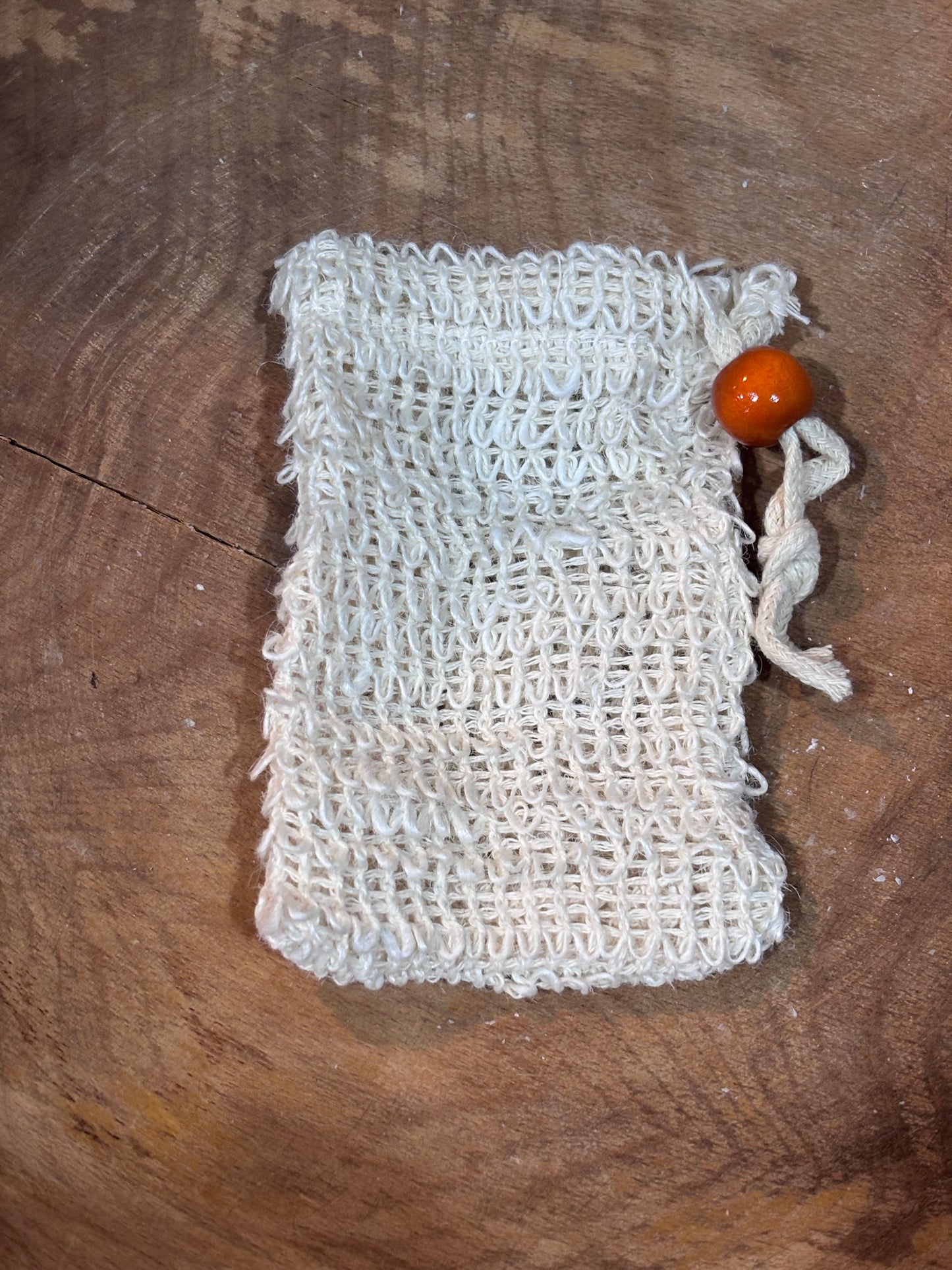 Sisal soap saver sitting in a wooden bowl
