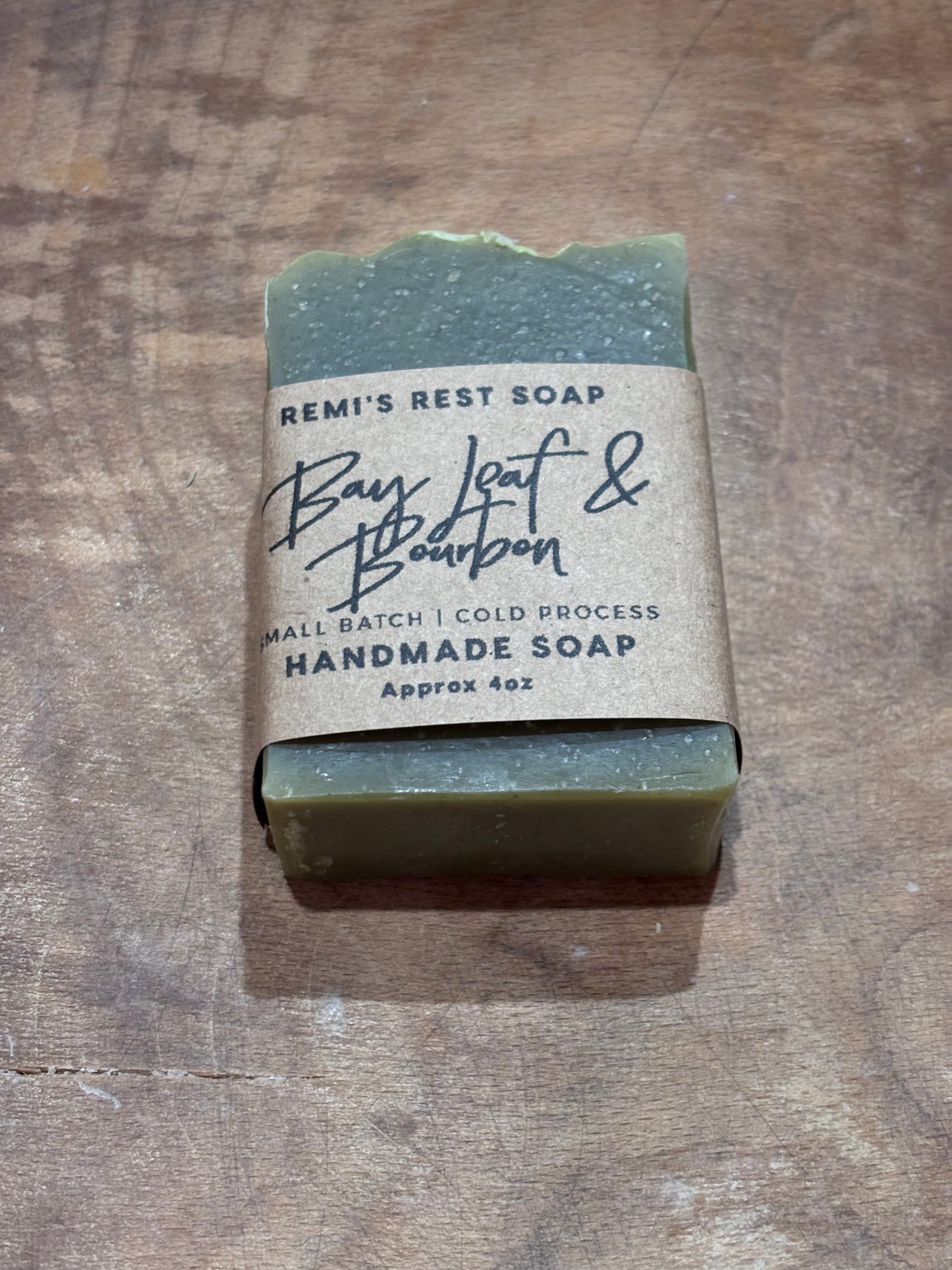 Bay Leaf & Bourbon. Dark green soap in a wooden bowl. 