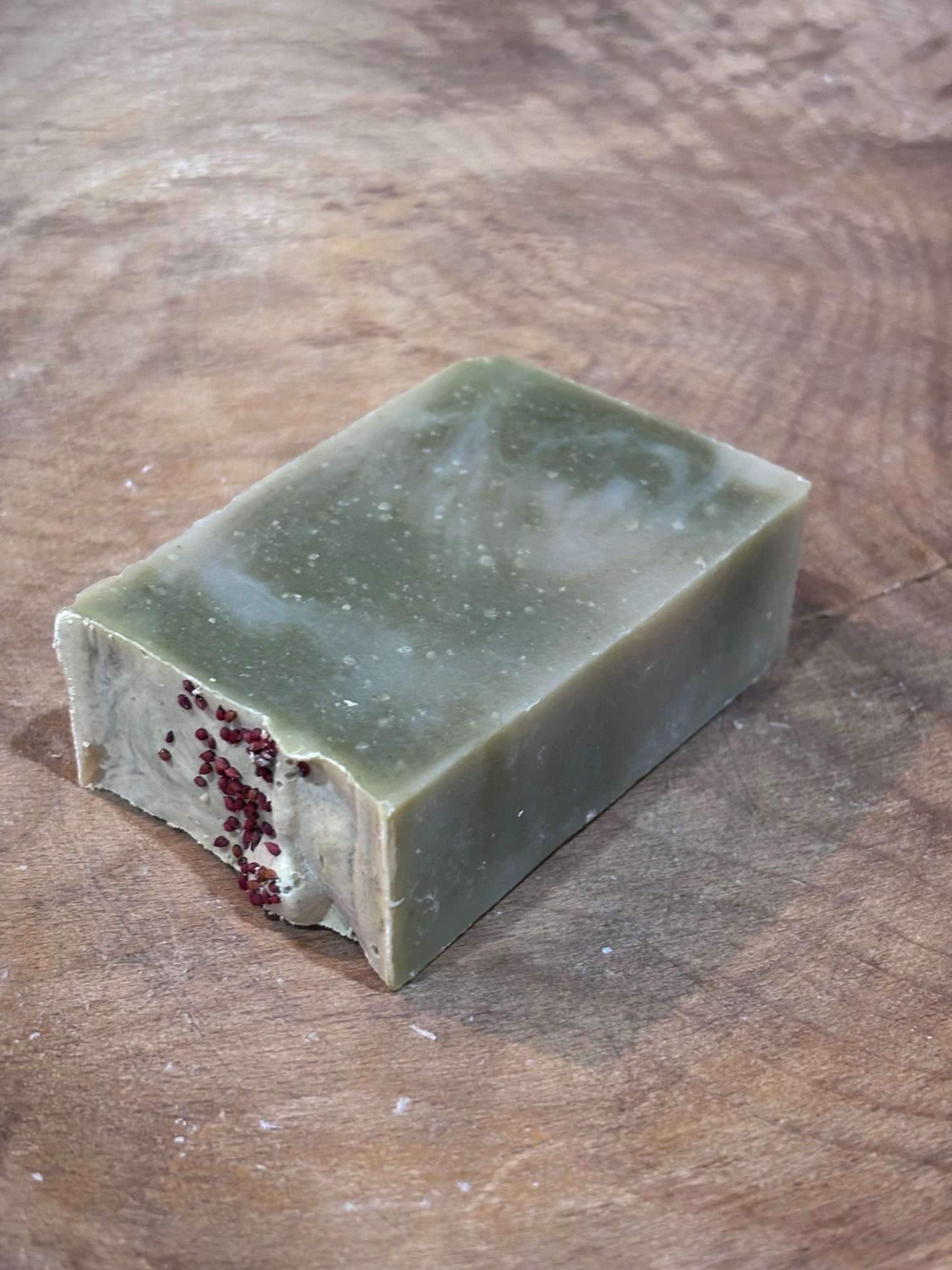 Lingonberry Spice soap. Green soap with red cranberry seeds on top for decoration. A clean scent that smells of high mountain pine and fresh air with hints of apple and musk.
Ingredients: water, olive oil, palm oil, coconut oil, castor oil, fragrance oil, spinach powder, cranberry seeds.
Because each bar is handmade and hand cut, exact colors and sizes may vary. Approx. weight is 4 oz.