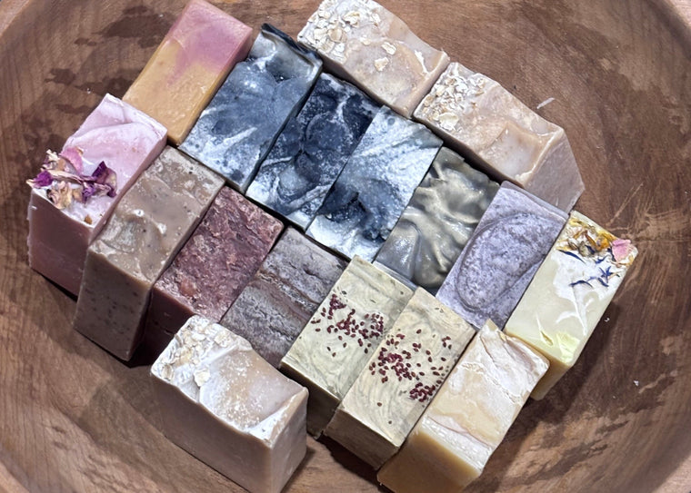 Wooden bowl containing multiple different handmade soaps